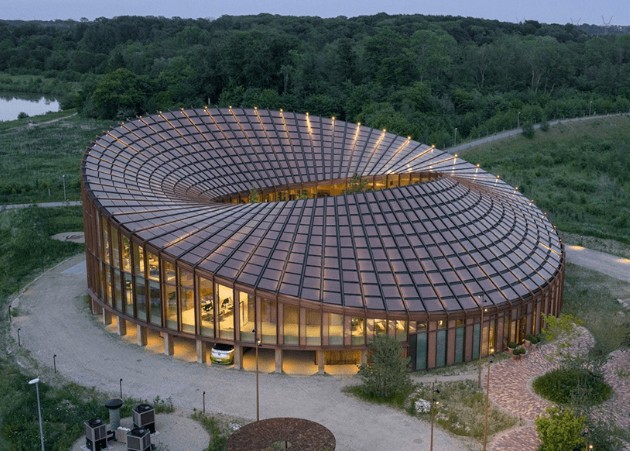 Una estructura de madera, un diseño circular y un patio escalonado dan forma a la sede de Dymak